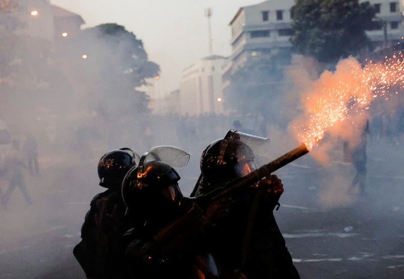 Demonstrators run from tear gas used by police during a protest demanding the resignation of President Gotabaya Rajapaksa, amid the country's economic crisis, near the president's residence in Colombo, Sri Lanka, July 9, 2022. REUTERS/Dinuka Liyanawatte