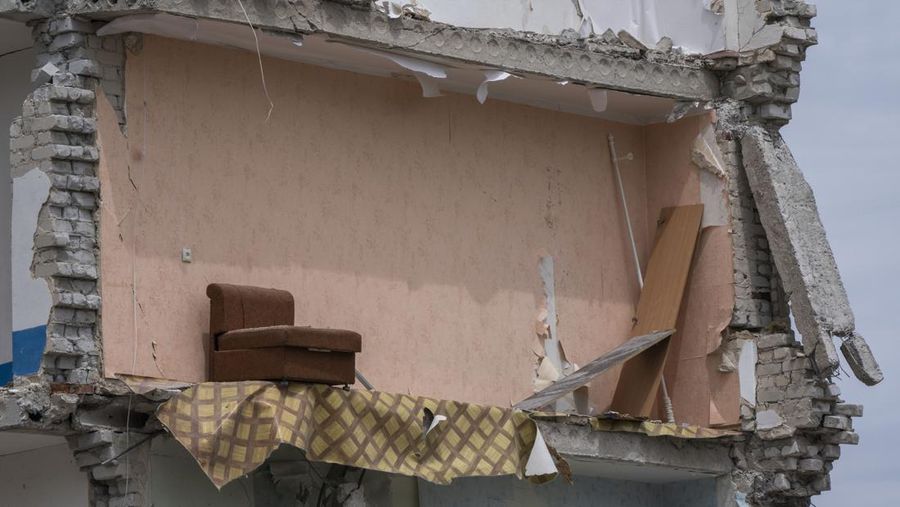 A sofa chair is seen in what is left standing in the aftermath of a Russian rocket that hit an apartment residential block, in Chasiv Yar, Donetsk region, eastern Ukraine, Sunday, July 10, 2022. At least 15 people were killed and more than 20 people may still be trapped in the rubble, officials said Sunday. (AP Photo/Nariman El-Mofty)