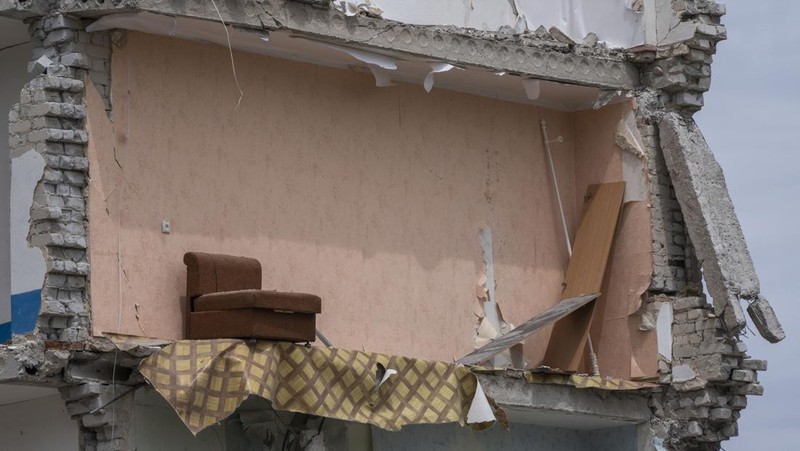 A sofa chair is seen in what is left standing in the aftermath of a Russian rocket that hit an apartment residential block, in Chasiv Yar, Donetsk region, eastern Ukraine, Sunday, July 10, 2022. At least 15 people were killed and more than 20 people may still be trapped in the rubble, officials said Sunday. (AP Photo/Nariman El-Mofty)