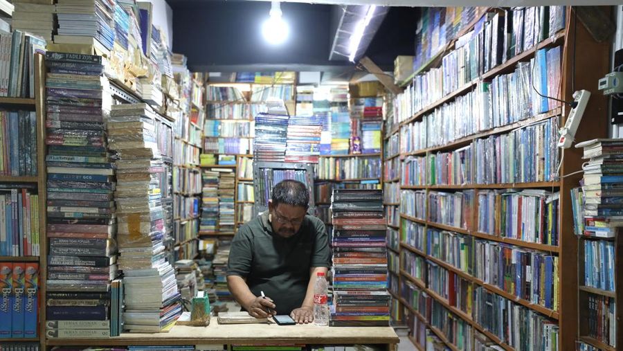 Sejumlah pedagang di toko buku Kenari, Jakarta merapikan buku pada rak di toko mereka masing-masing, Senin (11/7/2022). (CNBC Indonesia/Tri Susilo)
