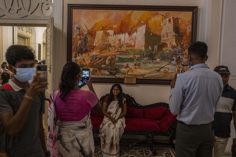 People queue up to visit President Gotabaya Rajapaksa's office for the second day after it was stormed in Colombo, Sri Lanka, Monday, July 11, 2022. Sri Lanka is in a political vacuum for a second day Monday with opposition leaders yet to agree on who should replace its roundly rejected leaders, whose residences are occupied by protesters, angry over the country's economic woes. (AP Photo/Eranga Jayawardena)