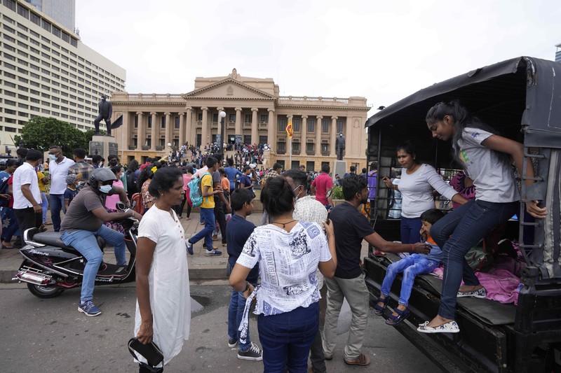 People queue up to visit President Gotabaya Rajapaksa's office for the second day after it was stormed in Colombo, Sri Lanka, Monday, July 11, 2022. Sri Lanka is in a political vacuum for a second day Monday with opposition leaders yet to agree on who should replace its roundly rejected leaders, whose residences are occupied by protesters, angry over the country's economic woes. (AP Photo/Eranga Jayawardena)