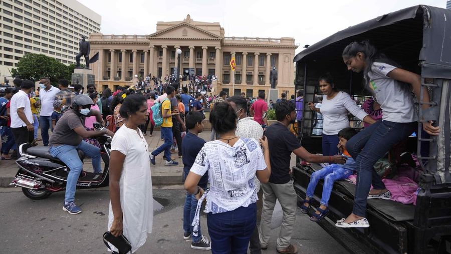 People queue up to visit President Gotabaya Rajapaksa's office for the second day after it was stormed in Colombo, Sri Lanka, Monday, July 11, 2022. Sri Lanka is in a political vacuum for a second day Monday with opposition leaders yet to agree on who should replace its roundly rejected leaders, whose residences are occupied by protesters, angry over the country's economic woes. (AP Photo/Eranga Jayawardena)