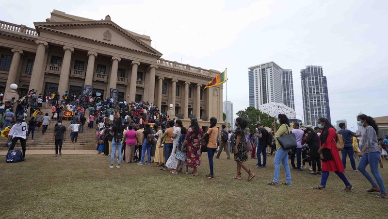 People queue up to visit President Gotabaya Rajapaksa's office for the second day after it was stormed in Colombo, Sri Lanka, Monday, July 11, 2022. Sri Lanka is in a political vacuum for a second day Monday with opposition leaders yet to agree on who should replace its roundly rejected leaders, whose residences are occupied by protesters, angry over the country's economic woes. (AP Photo/Eranga Jayawardena)