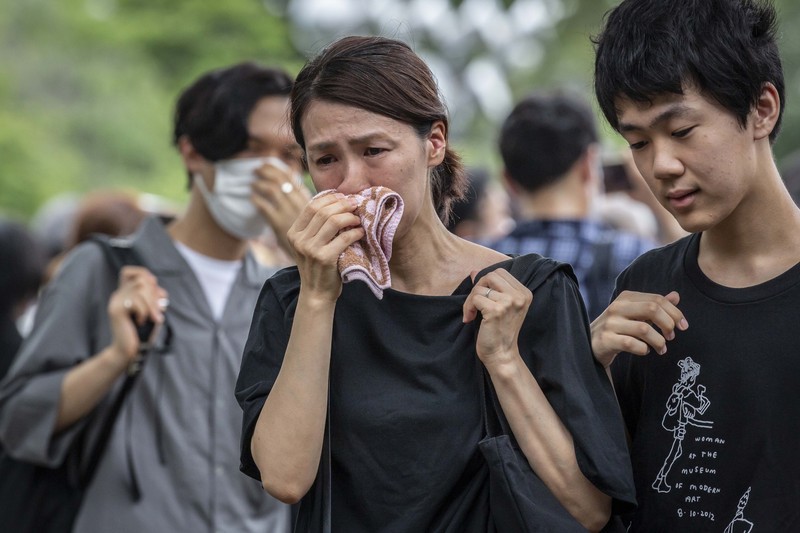 1408151607 TOKYO, JAPAN - JULY 12: A woman reacts during the funeral for former Japanese Prime Minister Shinzo Abe at Zojoji temple on July 12, 2022 in Tokyo, Japan. Abe was assassinated as he was campaigning at a rally in Nara on Friday. A suspect was apprehended and taken into custody, and confessed to shooting Abe with an improvised homemade gun. The killing of Japan's longest-serving prime minister in a country where gun violence is extremely rare has shocked the nation and the world. (Photo by Yuichi Yamazaki/Getty Images)