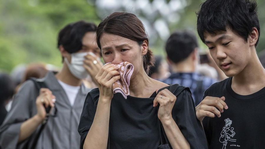 TOKYO, JAPAN - JULY 12: A woman reacts during the funeral for former Japanese Prime Minister Shinzo Abe at Zojoji temple on July 12, 2022 in Tokyo, Japan. Abe was assassinated as he was campaigning at a rally in Nara on Friday. A suspect was apprehended and taken into custody, and confessed to shooting Abe with an improvised homemade gun. The killing of Japan's longest-serving prime minister in a country where gun violence is extremely rare has shocked the nation and the world. (Photo by Yuichi Yamazaki/Getty Images)