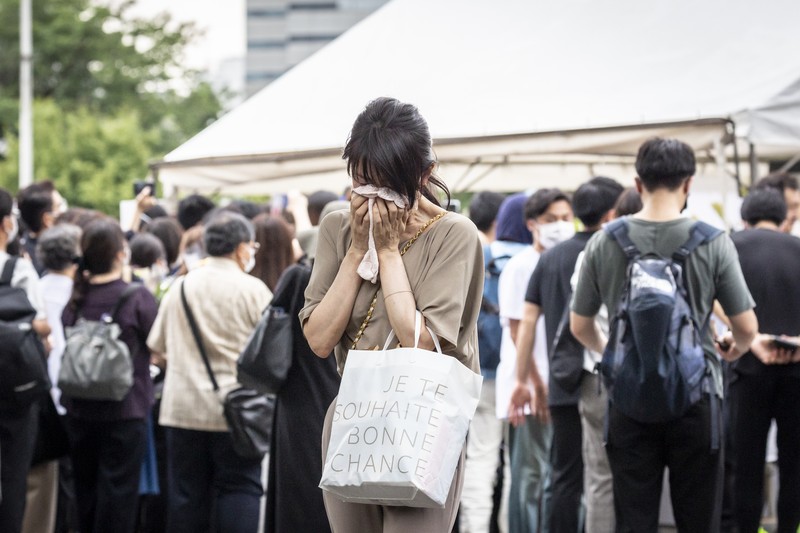 1408151607 TOKYO, JAPAN - JULY 12: A woman reacts during the funeral for former Japanese Prime Minister Shinzo Abe at Zojoji temple on July 12, 2022 in Tokyo, Japan. Abe was assassinated as he was campaigning at a rally in Nara on Friday. A suspect was apprehended and taken into custody, and confessed to shooting Abe with an improvised homemade gun. The killing of Japan's longest-serving prime minister in a country where gun violence is extremely rare has shocked the nation and the world. (Photo by Yuichi Yamazaki/Getty Images)