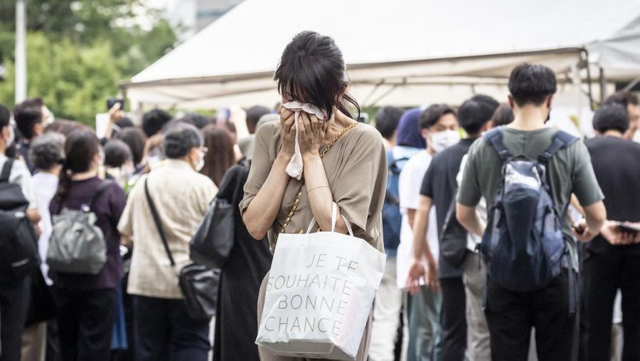 TOKYO, JAPAN - JULY 12: A woman reacts during the funeral for former Japanese Prime Minister Shinzo Abe at Zojoji temple on July 12, 2022 in Tokyo, Japan. Abe was assassinated as he was campaigning at a rally in Nara on Friday. A suspect was apprehended and taken into custody, and confessed to shooting Abe with an improvised homemade gun. The killing of Japan's longest-serving prime minister in a country where gun violence is extremely rare has shocked the nation and the world. (Photo by Yuichi Yamazaki/Getty Images)