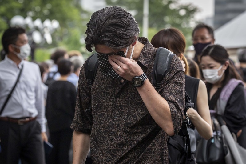 1408151607 TOKYO, JAPAN - JULY 12: A woman reacts during the funeral for former Japanese Prime Minister Shinzo Abe at Zojoji temple on July 12, 2022 in Tokyo, Japan. Abe was assassinated as he was campaigning at a rally in Nara on Friday. A suspect was apprehended and taken into custody, and confessed to shooting Abe with an improvised homemade gun. The killing of Japan's longest-serving prime minister in a country where gun violence is extremely rare has shocked the nation and the world. (Photo by Yuichi Yamazaki/Getty Images)