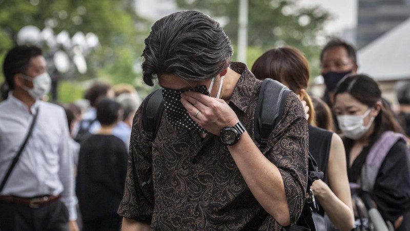TOKYO, JAPAN - JULY 12: A woman reacts during the funeral for former Japanese Prime Minister Shinzo Abe at Zojoji temple on July 12, 2022 in Tokyo, Japan. Abe was assassinated as he was campaigning at a rally in Nara on Friday. A suspect was apprehended and taken into custody, and confessed to shooting Abe with an improvised homemade gun. The killing of Japan's longest-serving prime minister in a country where gun violence is extremely rare has shocked the nation and the world. (Photo by Yuichi Yamazaki/Getty Images)
