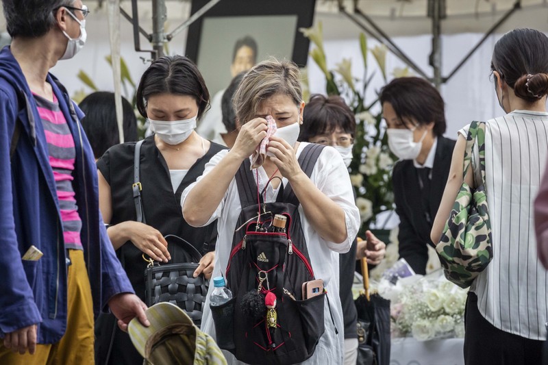 1408151607 TOKYO, JAPAN - JULY 12: A woman reacts during the funeral for former Japanese Prime Minister Shinzo Abe at Zojoji temple on July 12, 2022 in Tokyo, Japan. Abe was assassinated as he was campaigning at a rally in Nara on Friday. A suspect was apprehended and taken into custody, and confessed to shooting Abe with an improvised homemade gun. The killing of Japan's longest-serving prime minister in a country where gun violence is extremely rare has shocked the nation and the world. (Photo by Yuichi Yamazaki/Getty Images)