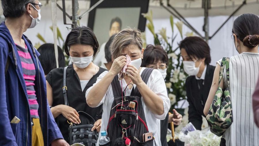 TOKYO, JAPAN - JULY 12: A woman reacts during the funeral for former Japanese Prime Minister Shinzo Abe at Zojoji temple on July 12, 2022 in Tokyo, Japan. Abe was assassinated as he was campaigning at a rally in Nara on Friday. A suspect was apprehended and taken into custody, and confessed to shooting Abe with an improvised homemade gun. The killing of Japan's longest-serving prime minister in a country where gun violence is extremely rare has shocked the nation and the world. (Photo by Yuichi Yamazaki/Getty Images)
