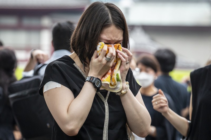 1408151607 TOKYO, JAPAN - JULY 12: A woman reacts during the funeral for former Japanese Prime Minister Shinzo Abe at Zojoji temple on July 12, 2022 in Tokyo, Japan. Abe was assassinated as he was campaigning at a rally in Nara on Friday. A suspect was apprehended and taken into custody, and confessed to shooting Abe with an improvised homemade gun. The killing of Japan's longest-serving prime minister in a country where gun violence is extremely rare has shocked the nation and the world. (Photo by Yuichi Yamazaki/Getty Images)