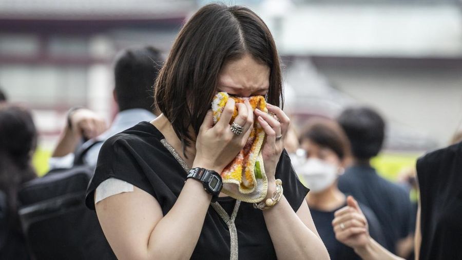 TOKYO, JAPAN - JULY 12: A woman reacts during the funeral for former Japanese Prime Minister Shinzo Abe at Zojoji temple on July 12, 2022 in Tokyo, Japan. Abe was assassinated as he was campaigning at a rally in Nara on Friday. A suspect was apprehended and taken into custody, and confessed to shooting Abe with an improvised homemade gun. The killing of Japan's longest-serving prime minister in a country where gun violence is extremely rare has shocked the nation and the world. (Photo by Yuichi Yamazaki/Getty Images)