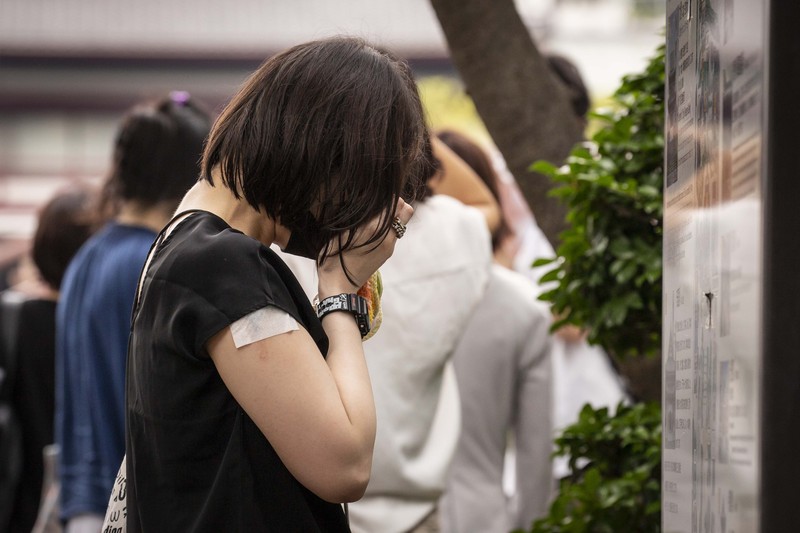 1408151607 TOKYO, JAPAN - JULY 12: A woman reacts during the funeral for former Japanese Prime Minister Shinzo Abe at Zojoji temple on July 12, 2022 in Tokyo, Japan. Abe was assassinated as he was campaigning at a rally in Nara on Friday. A suspect was apprehended and taken into custody, and confessed to shooting Abe with an improvised homemade gun. The killing of Japan's longest-serving prime minister in a country where gun violence is extremely rare has shocked the nation and the world. (Photo by Yuichi Yamazaki/Getty Images)