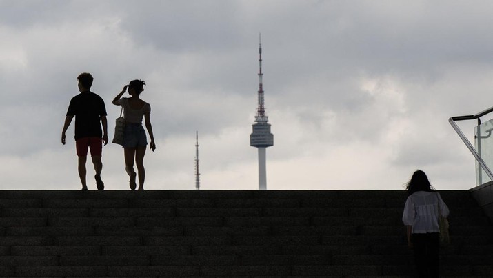 1241752853 People are silhouetted against the sky, with a view of the Namsan Seoul Tower (R) as they visit the National Museum of Korea in Seoul on July 7, 2022. (Photo by Anthony WALLACE / AFP) (Photo by ANTHONY WALLACE/AFP via Getty Images)