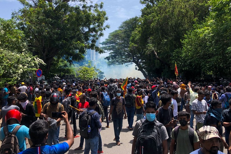 Police use teargas as Sri Lankan protesters storm the compound of prime minister Ranil Wickremesinghe 's office, demanding he resign after president Gotabaya Rajapaksa fled amid economic crisis in Colombo, Sri Lanka, Wednesday, July 13, 2022. (AP Photo/Rafiq Maqbool)