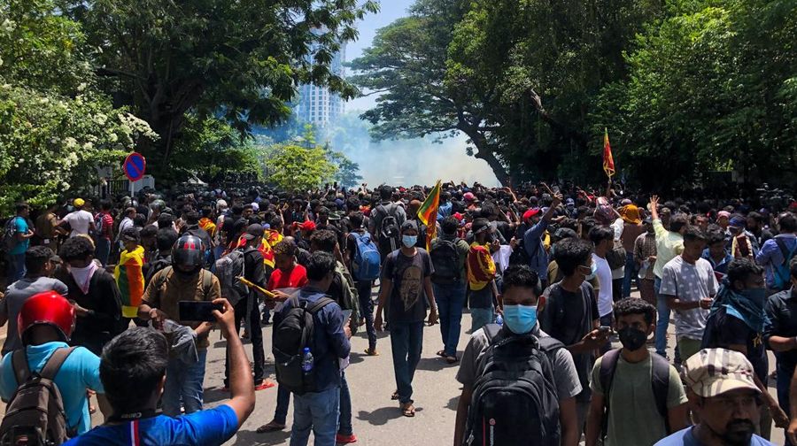 Police use teargas as Sri Lankan protesters storm the compound of prime minister Ranil Wickremesinghe 's office, demanding he resign after president Gotabaya Rajapaksa fled amid economic crisis in Colombo, Sri Lanka, Wednesday, July 13, 2022. (AP Photo/Rafiq Maqbool)