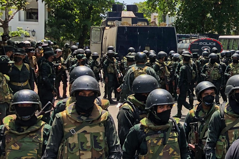 Police use teargas as Sri Lankan protesters storm the compound of prime minister Ranil Wickremesinghe 's office, demanding he resign after president Gotabaya Rajapaksa fled amid economic crisis in Colombo, Sri Lanka, Wednesday, July 13, 2022. (AP Photo/Rafiq Maqbool)