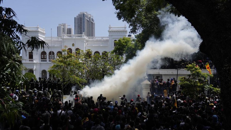 Police use teargas as Sri Lankan protesters storm the compound of prime minister Ranil Wickremesinghe 's office, demanding he resign after president Gotabaya Rajapaksa fled amid economic crisis in Colombo, Sri Lanka, Wednesday, July 13, 2022. (AP Photo/Rafiq Maqbool)