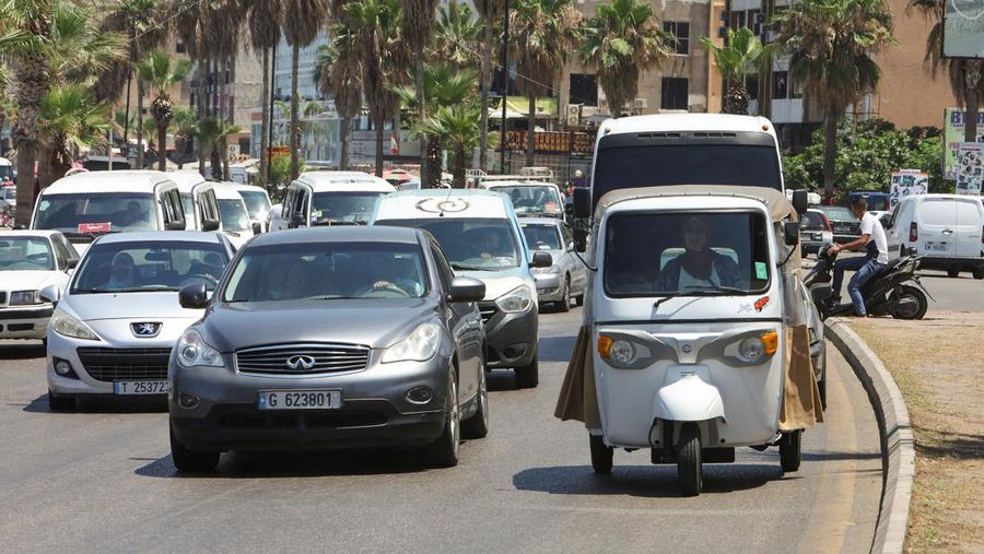 Hala Mohammed al-Yaman, Lebanese mother and tuk-tuk driver, stands next to her tuk-tuk at the corniche in the port city of Sidon, Lebanon June 28, 2022. REUTERS/Aziz Taher