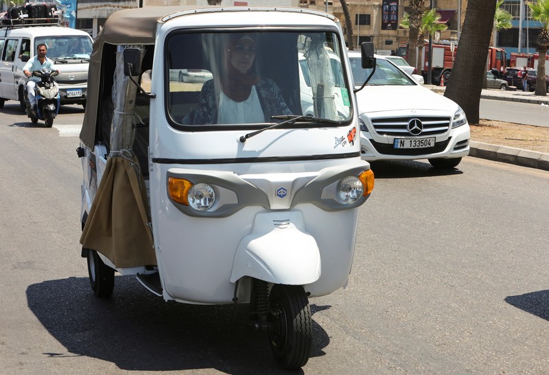 Hala Mohammed al-Yaman, Lebanese mother and tuk-tuk driver, stands next to her tuk-tuk at the corniche in the port city of Sidon, Lebanon June 28, 2022. REUTERS/Aziz Taher