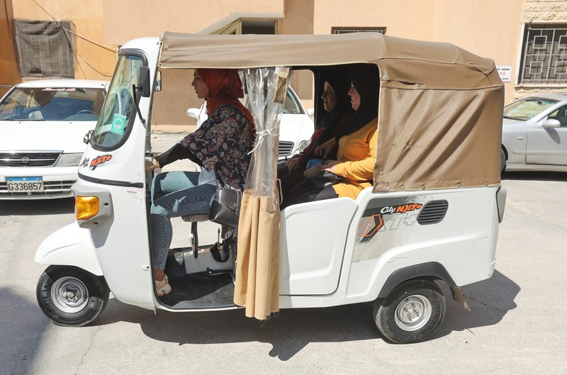 Hala Mohammed al-Yaman, Lebanese mother and tuk-tuk driver, stands next to her tuk-tuk at the corniche in the port city of Sidon, Lebanon June 28, 2022. REUTERS/Aziz Taher