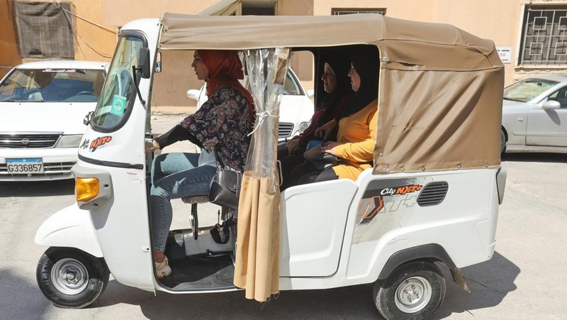 Hala Mohammed al-Yaman, Lebanese mother and tuk-tuk driver, stands next to her tuk-tuk at the corniche in the port city of Sidon, Lebanon June 28, 2022. REUTERS/Aziz Taher