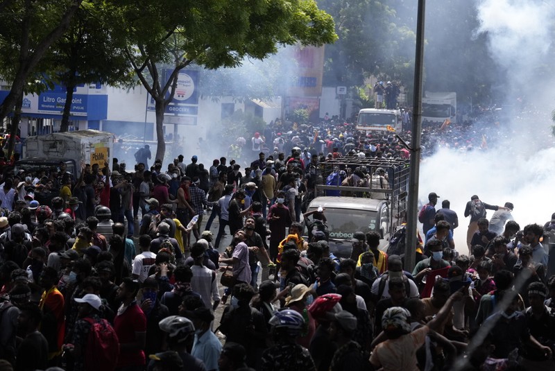 APTOPIX Sri Lanka Police use teargas as Sri Lankan protesters storm the compound of prime minister Ranil Wickremesinghe 's office, demanding he resign after president Gotabaya Rajapaksa fled amid economic crisis in Colombo, Sri Lanka, Wednesday, July 13, 2022. (AP Photo/Rafiq Maqbool)