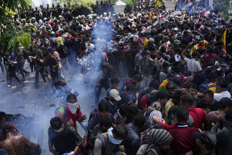 Police use teargas as Sri Lankan protesters storm the compound of prime minister Ranil Wickremesinghe 's office, demanding he resign after president Gotabaya Rajapaksa fled amid economic crisis in Colombo, Sri Lanka, Wednesday, July 13, 2022. (AP Photo/Rafiq Maqbool)