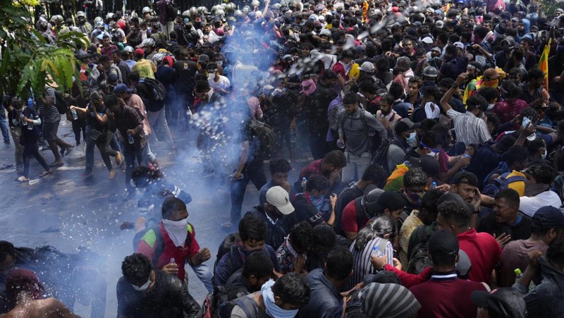 Police use teargas as Sri Lankan protesters storm the compound of prime minister Ranil Wickremesinghe 's office, demanding he resign after president Gotabaya Rajapaksa fled amid economic crisis in Colombo, Sri Lanka, Wednesday, July 13, 2022. (AP Photo/Rafiq Maqbool)