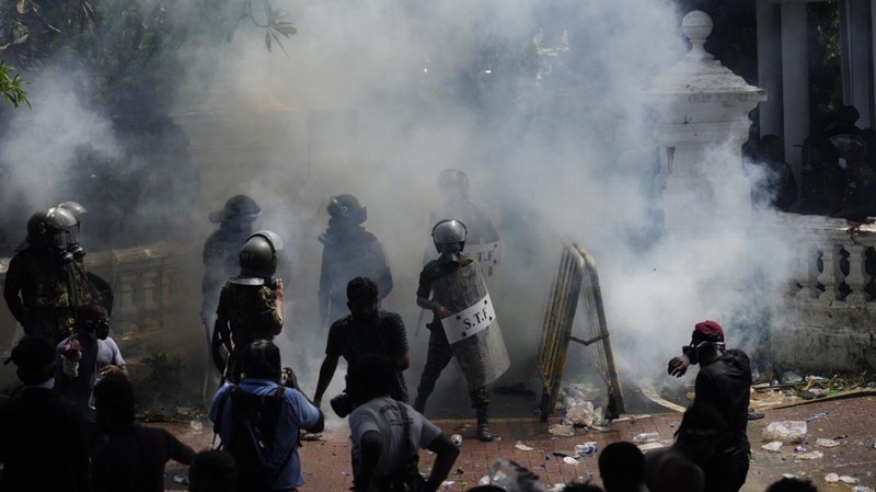 Police use teargas as Sri Lankan protesters storm the compound of prime minister Ranil Wickremesinghe 's office, demanding he resign after president Gotabaya Rajapaksa fled amid economic crisis in Colombo, Sri Lanka, Wednesday, July 13, 2022. (AP Photo/Rafiq Maqbool)