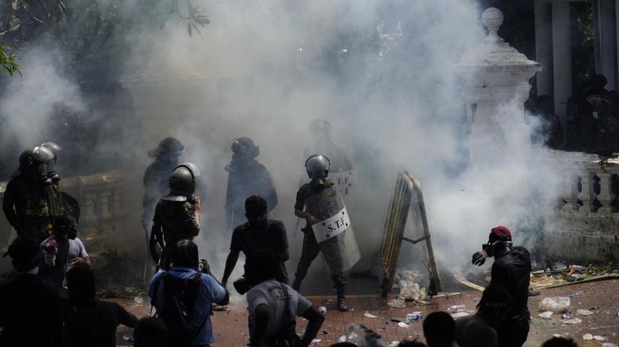 Police use teargas as Sri Lankan protesters storm the compound of prime minister Ranil Wickremesinghe 's office, demanding he resign after president Gotabaya Rajapaksa fled amid economic crisis in Colombo, Sri Lanka, Wednesday, July 13, 2022. (AP Photo/Rafiq Maqbool)