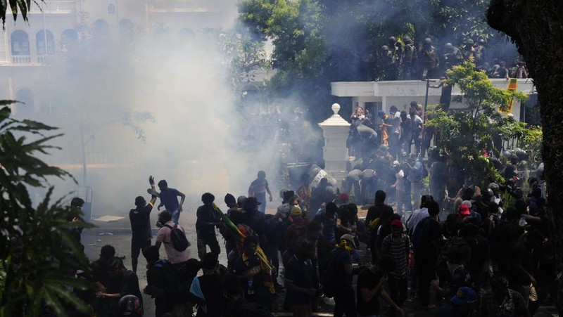 Police use teargas as Sri Lankan protesters storm the compound of prime minister Ranil Wickremesinghe 's office, demanding he resign after president Gotabaya Rajapaksa fled amid economic crisis in Colombo, Sri Lanka, Wednesday, July 13, 2022. (AP Photo/Rafiq Maqbool)
