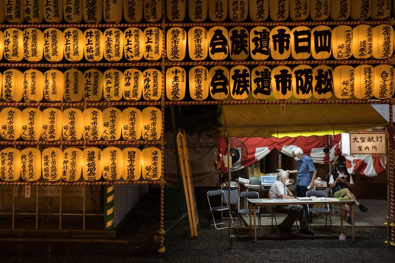 FESTIVAL-JAPAN/ Women in yukata, or casual summer kimonos, wearing protective mask amid the coronavirus disease (COVID-19) outbreak, walk between lanterns during the annual Mitama Festival at the Yasukuni Shrine, where more than 2.4 million war dead are enshrined, in Tokyo, Japan, July 13, 2022. REUTERS/Kim Kyung-Hoon