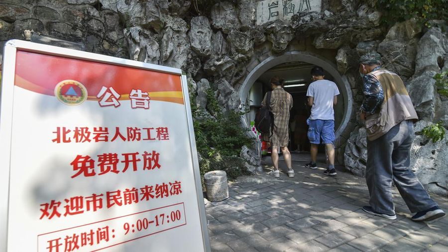 A sign announces the opening hours of an air raid shelter to residents to cool off from the hot weather in Nanjing in east China's Jiangsu province Sunday, July 10, 2022. High temperatures have prompted cites in eastern China to open former air raid shelters as a relief from the heat. (Chinatopix via AP)