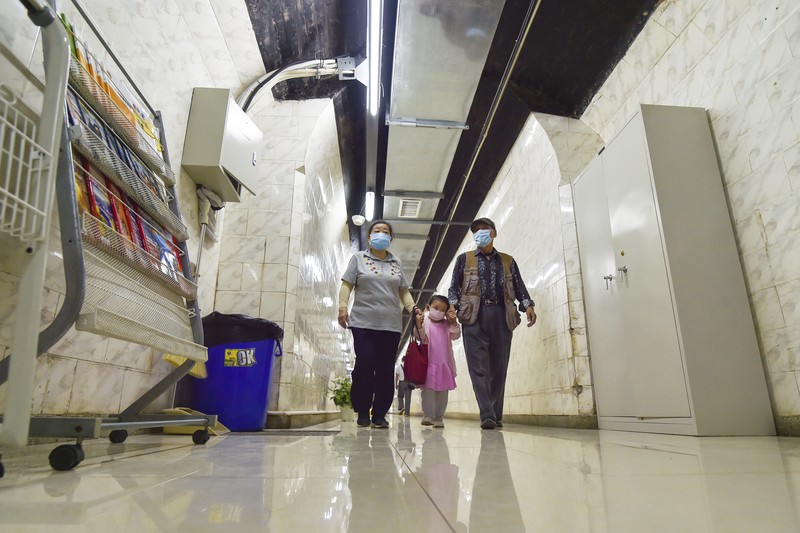 A sign announces the opening hours of an air raid shelter to residents to cool off from the hot weather in Nanjing in east China's Jiangsu province Sunday, July 10, 2022. High temperatures have prompted cites in eastern China to open former air raid shelters as a relief from the heat. (Chinatopix via AP)