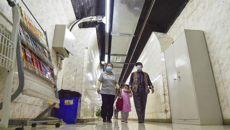 A sign announces the opening hours of an air raid shelter to residents to cool off from the hot weather in Nanjing in east China's Jiangsu province Sunday, July 10, 2022. High temperatures have prompted cites in eastern China to open former air raid shelters as a relief from the heat. (Chinatopix via AP)