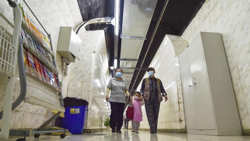 A sign announces the opening hours of an air raid shelter to residents to cool off from the hot weather in Nanjing in east China's Jiangsu province Sunday, July 10, 2022. High temperatures have prompted cites in eastern China to open former air raid shelters as a relief from the heat. (Chinatopix via AP)