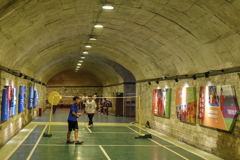 A sign announces the opening hours of an air raid shelter to residents to cool off from the hot weather in Nanjing in east China's Jiangsu province Sunday, July 10, 2022. High temperatures have prompted cites in eastern China to open former air raid shelters as a relief from the heat. (Chinatopix via AP)