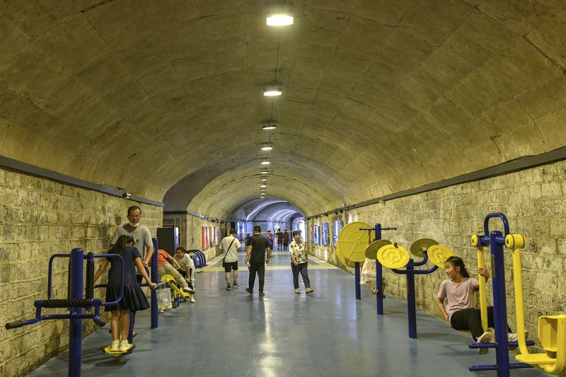 A sign announces the opening hours of an air raid shelter to residents to cool off from the hot weather in Nanjing in east China's Jiangsu province Sunday, July 10, 2022. High temperatures have prompted cites in eastern China to open former air raid shelters as a relief from the heat. (Chinatopix via AP)