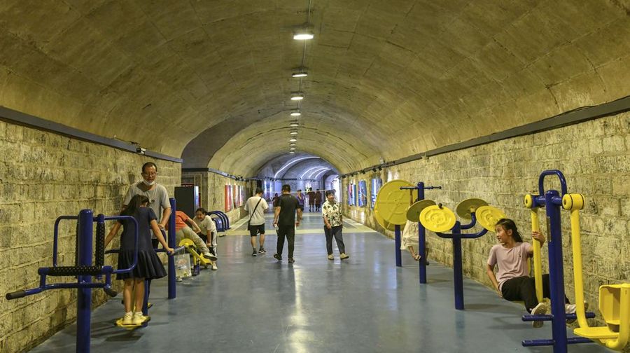 A sign announces the opening hours of an air raid shelter to residents to cool off from the hot weather in Nanjing in east China's Jiangsu province Sunday, July 10, 2022. High temperatures have prompted cites in eastern China to open former air raid shelters as a relief from the heat. (Chinatopix via AP)