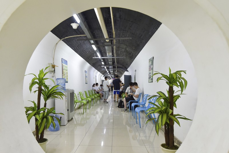 A sign announces the opening hours of an air raid shelter to residents to cool off from the hot weather in Nanjing in east China's Jiangsu province Sunday, July 10, 2022. High temperatures have prompted cites in eastern China to open former air raid shelters as a relief from the heat. (Chinatopix via AP)