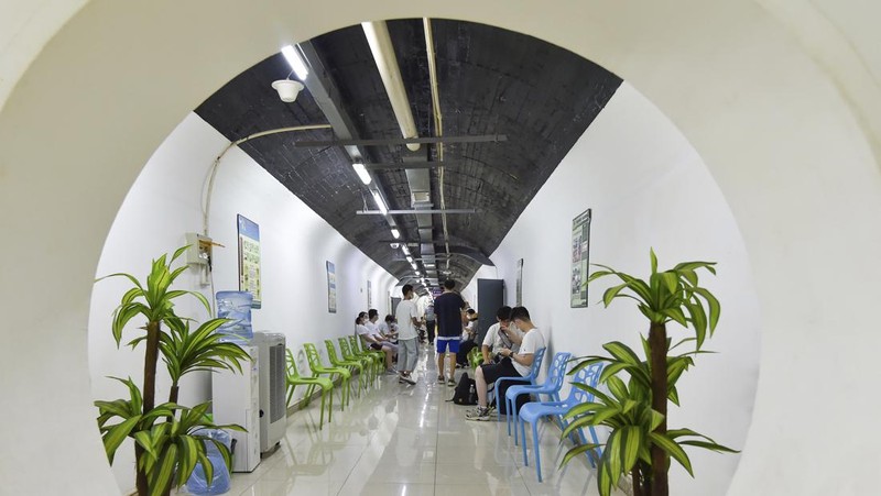 A sign announces the opening hours of an air raid shelter to residents to cool off from the hot weather in Nanjing in east China's Jiangsu province Sunday, July 10, 2022. High temperatures have prompted cites in eastern China to open former air raid shelters as a relief from the heat. (Chinatopix via AP)