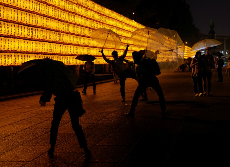 Women in yukata, or casual summer kimonos, wearing protective mask amid the coronavirus disease (COVID-19) outbreak, walk between lanterns during the annual Mitama Festival at the Yasukuni Shrine, where more than 2.4 million war dead are enshrined, in Tokyo, Japan, July 13, 2022. REUTERS/Kim Kyung-Hoon