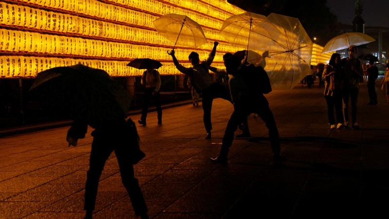 Women in yukata, or casual summer kimonos, wearing protective mask amid the coronavirus disease (COVID-19) outbreak, walk between lanterns during the annual Mitama Festival at the Yasukuni Shrine, where more than 2.4 million war dead are enshrined, in Tokyo, Japan, July 13, 2022. REUTERS/Kim Kyung-Hoon