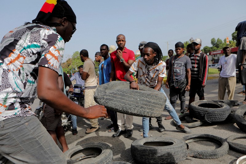 A demonstrator throws a tyre on a burning road block as anger mounted over fuel shortages that have intensified as a result of gang violence, in Port-au-Prince, Haiti, July 13, 2022. REUTERS/Ralph Tedy Erol REFILE - QUALITY REPEAT