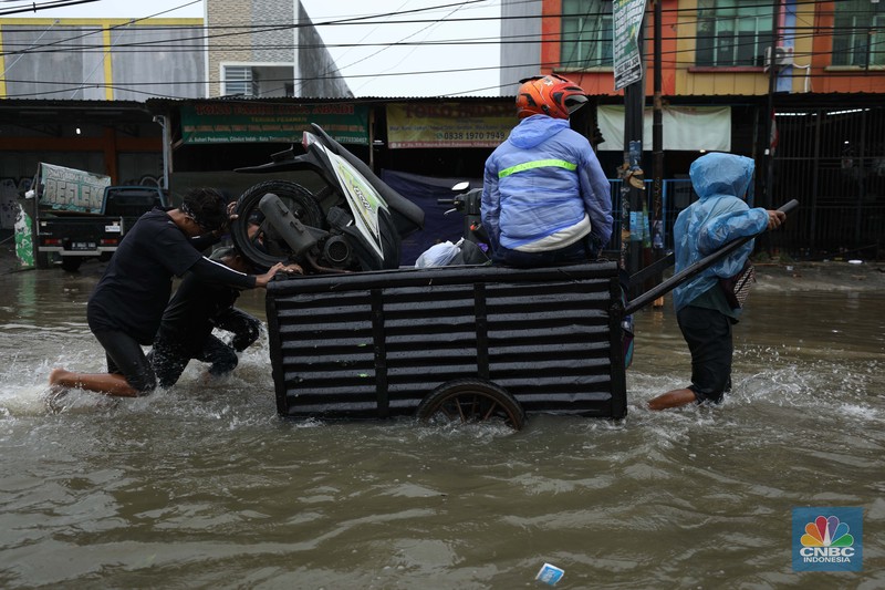 Pengendara sepeda motor menggunakan jasa gerobak saat melintasi banjir di Ciledug, Tangerang Banten, Sabtu (16/7/2022). (CNBC Indonesia/Tri Susilo) Pengendara sepeda motor menggunakan jasa gerobak saat melintasi banjir di Ciledug, Tangerang Banten, Sabtu (16/7/2022). (CNBC Indonesia/Tri Susilo)