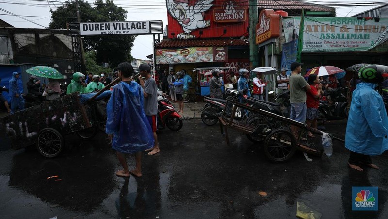 Pengendara sepeda motor menggunakan jasa gerobak saat melintasi banjir di Ciledug, Tangerang Banten, Sabtu (16/7/2022). (CNBC Indonesia/Tri Susilo)