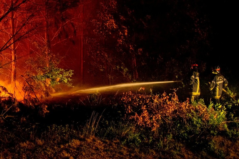 Petugas pemadam kebakaran bekerja setelah kebakaran yang terjadi di dekat Landiras, saat kebakaran hutan terus menyebar di wilayah Gironde di barat daya Prancis, Sabtu (16/7/2022). (SDIS 33 via AP)